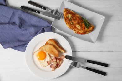 Photo of Omelet, fried eggs with bacon and toasted bread served for breakfast, top view