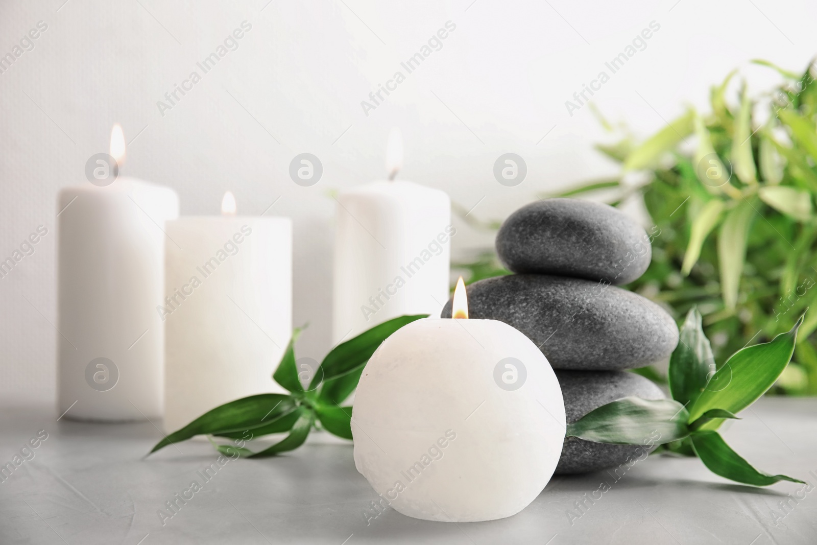 Photo of Beautiful spa composition with candles and stones on table