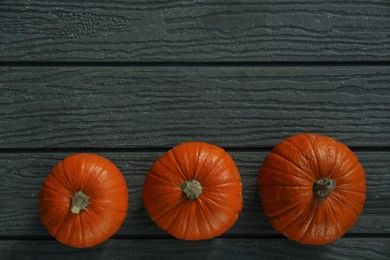 Many whole ripe pumpkins on wooden table, flat lay. Space for text