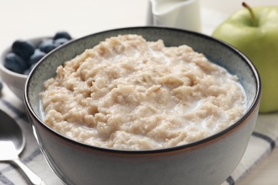 Tasty oatmeal porridge served on table, closeup