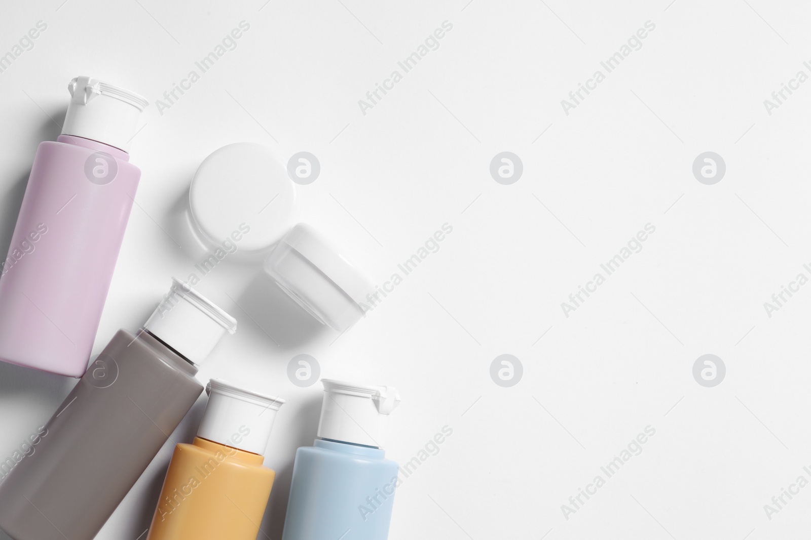 Photo of Cosmetic travel kit on white background, flat lay. Space for text