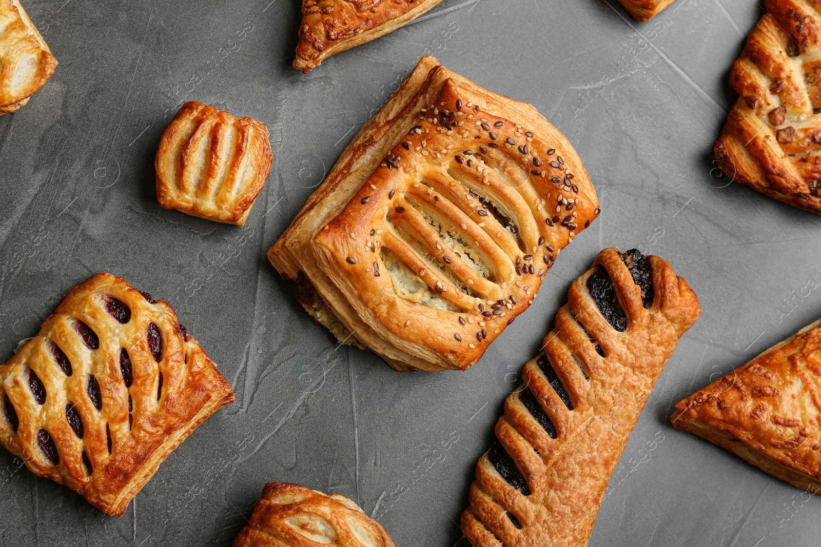 Photo of Flat lay composition with fresh delicious puff pastry on grey table