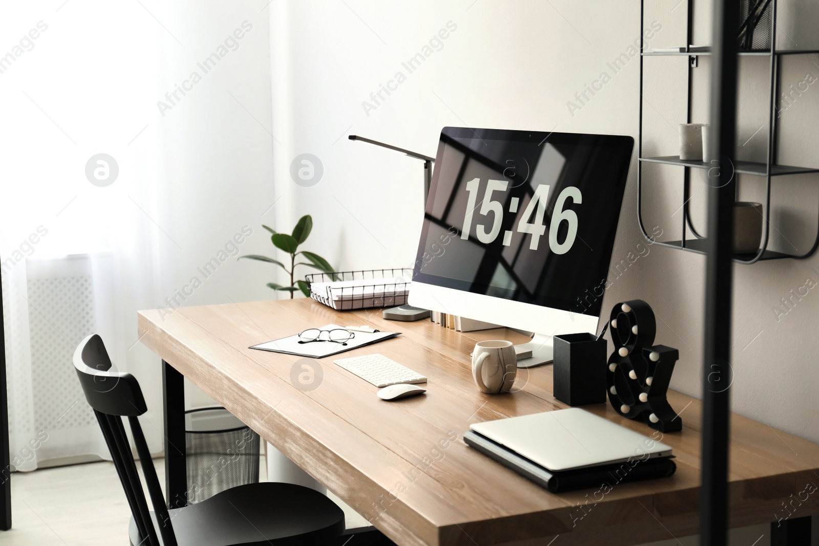 Photo of Modern workplace with computer in room. Interior design