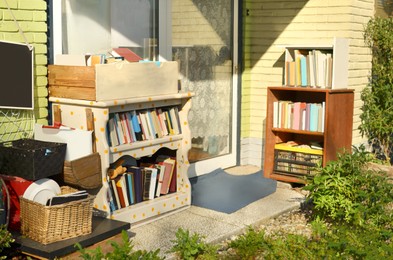 Photo of Many books and some other stuff near house. Yard sale