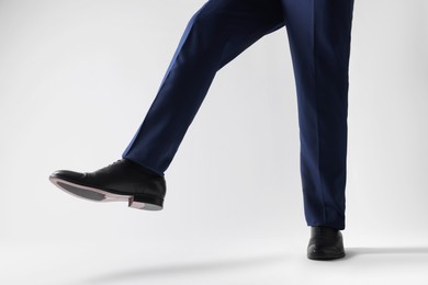 Photo of Businessman in leather shoes on white background, closeup