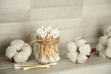 Cotton swabs and flowers on tiled surface indoors