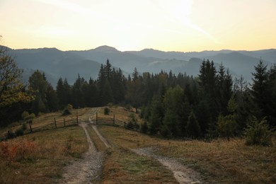 Photo of Picturesque view of mountain landscape with forest and wooden fence