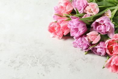 Beautiful bouquet of colorful tulip flowers on light grey table. Space for text