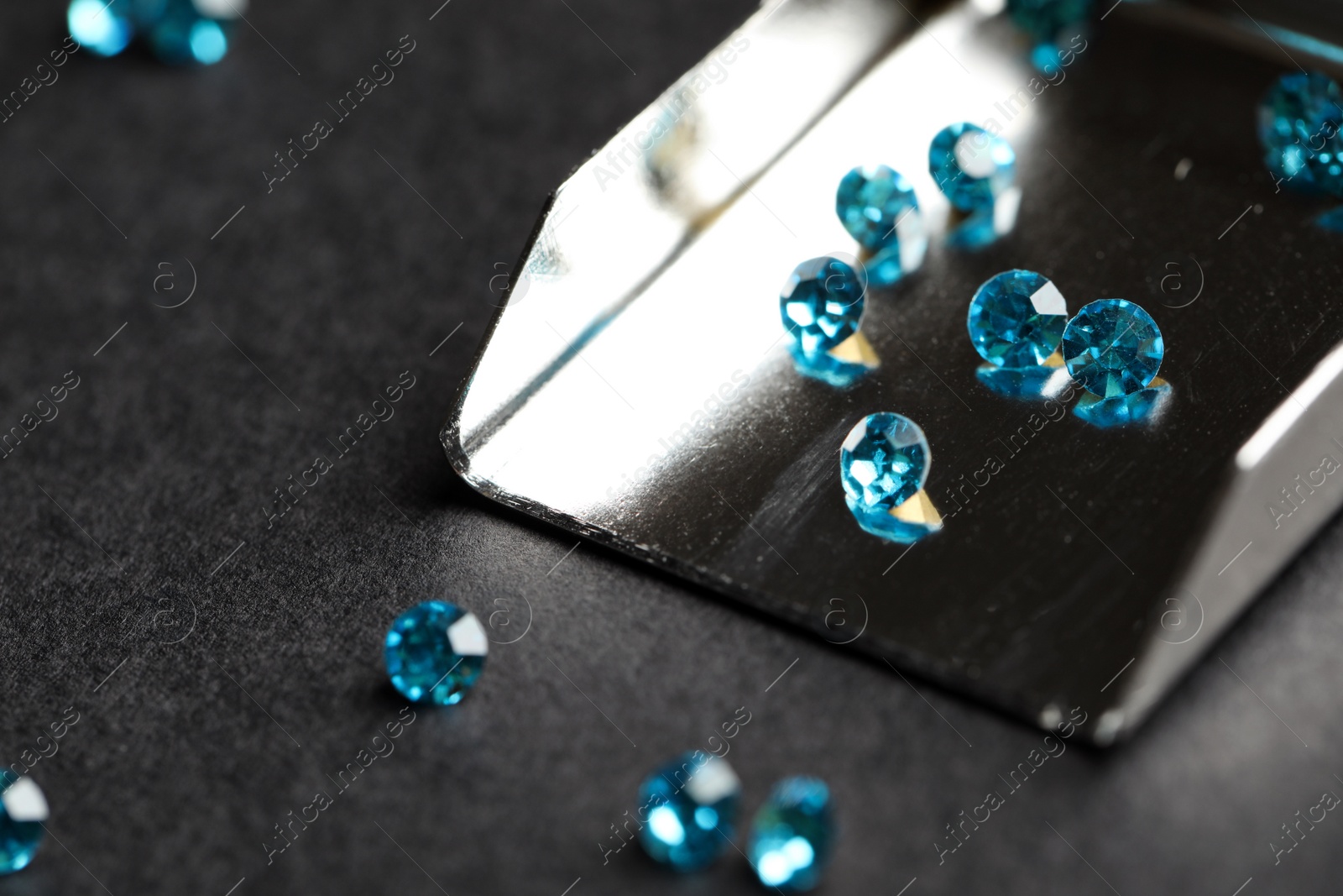 Photo of Beautiful gemstones and jewelry scoop on grey table