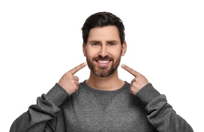 Photo of Smiling man pointing at his healthy clean teeth on white background