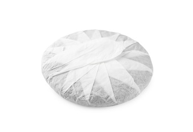 Disc shaped traditional Chinese pu-erh tea in paper wrap isolated on white