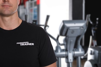 Image of Professional personal trainer in gym, closeup. Space for text