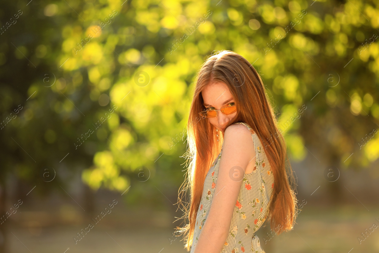 Photo of Beautiful young woman wearing sunglasses in green park