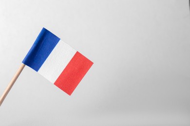 Photo of Small paper flag of France on light background. Space for text