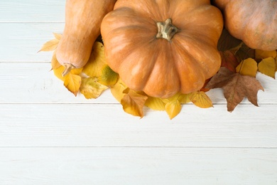 Ripe pumpkins on wooden background, flat lay with space for text. Holiday decoration