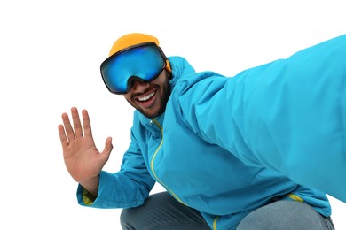 Photo of Smiling young man in ski goggles taking selfie on white background
