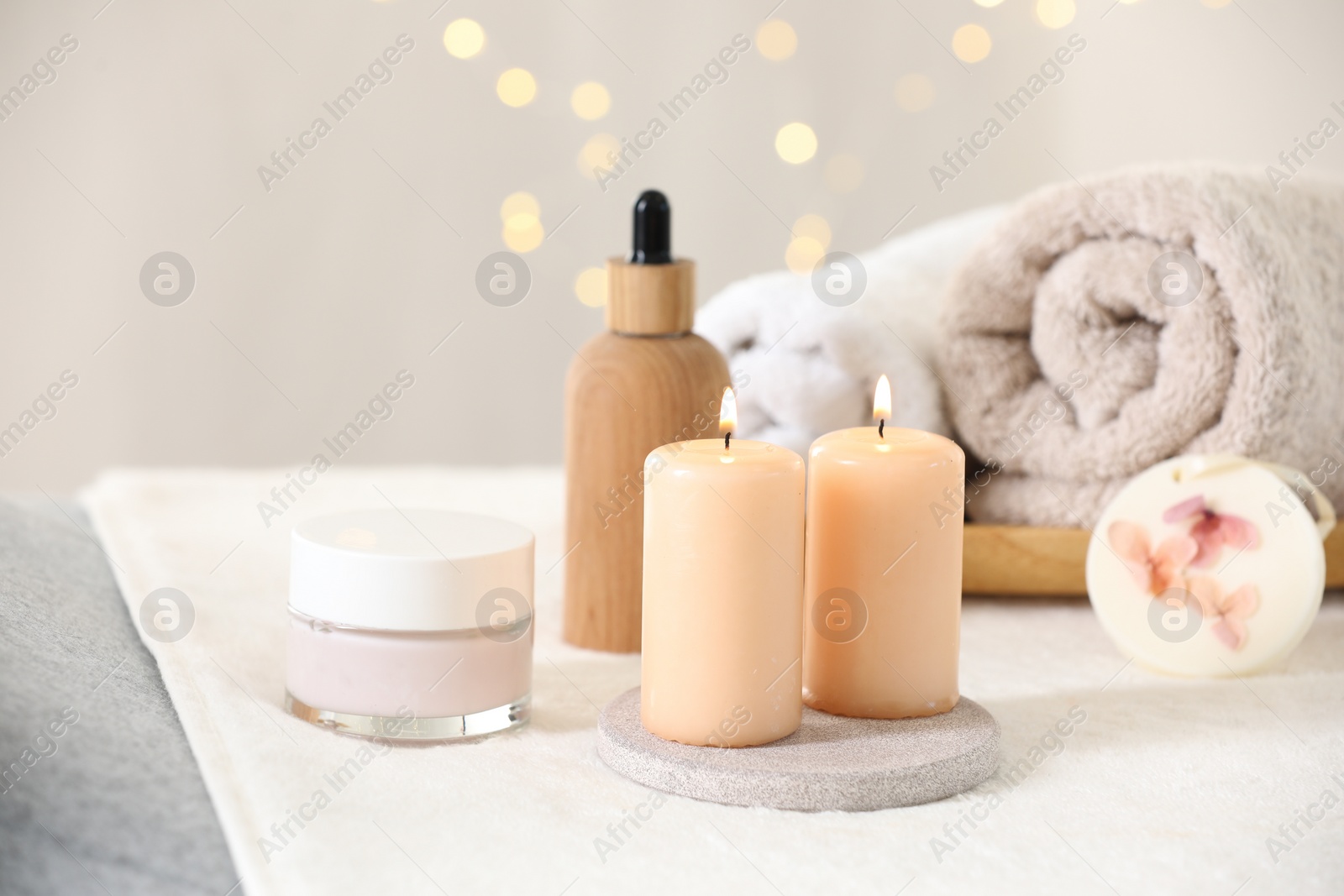 Photo of Spa composition. Burning candles and personal care products on soft surface