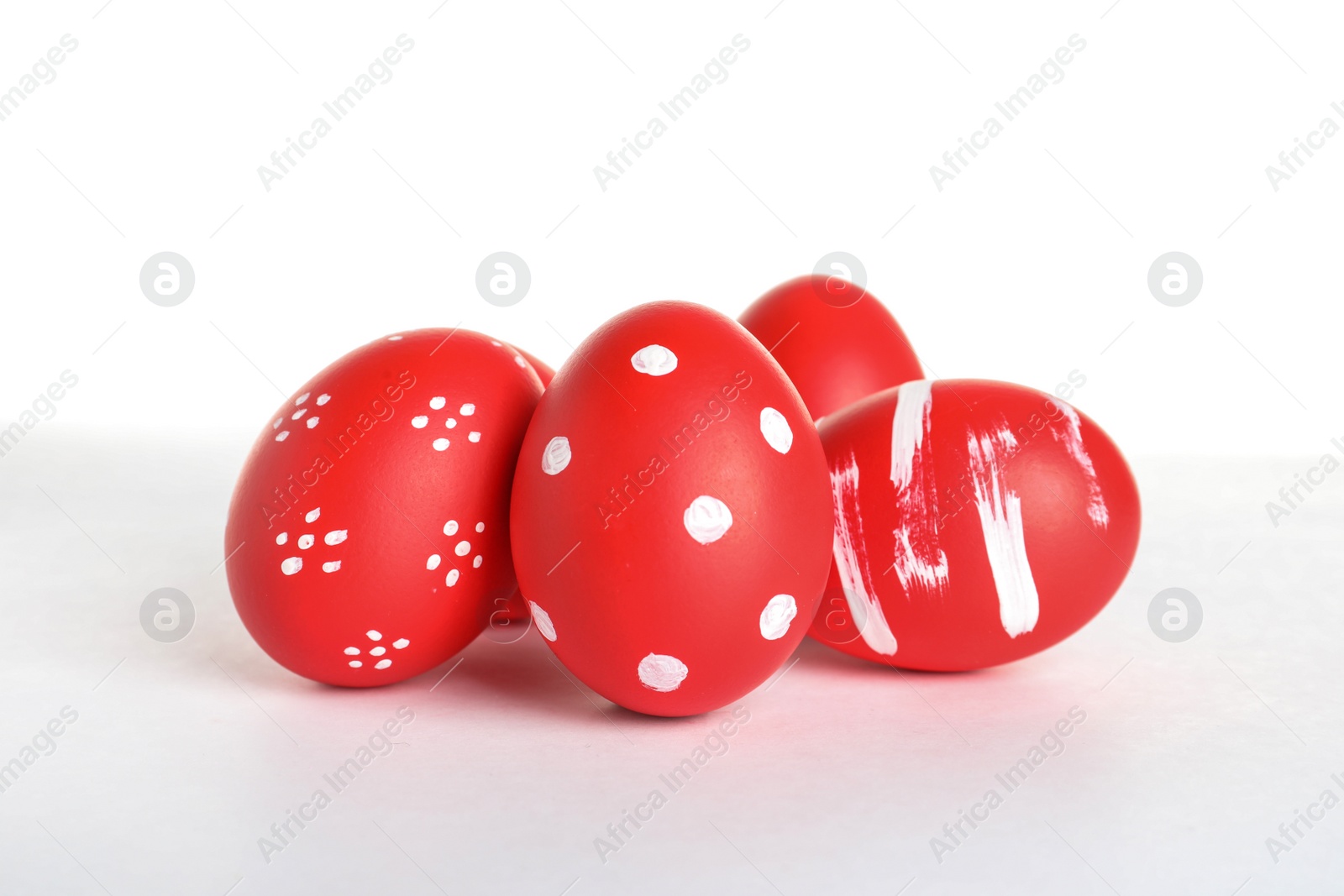 Photo of Creative painted red Easter eggs on white background