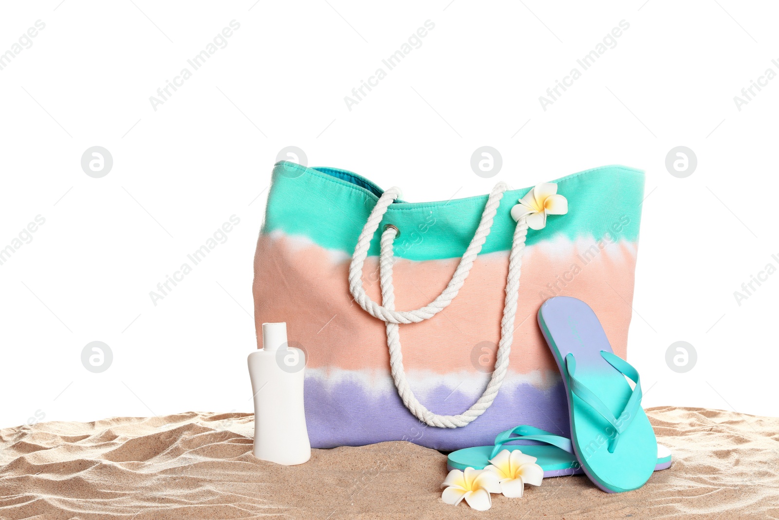 Photo of Stylish colorful bag and beach accessories on sand against white background, space for text