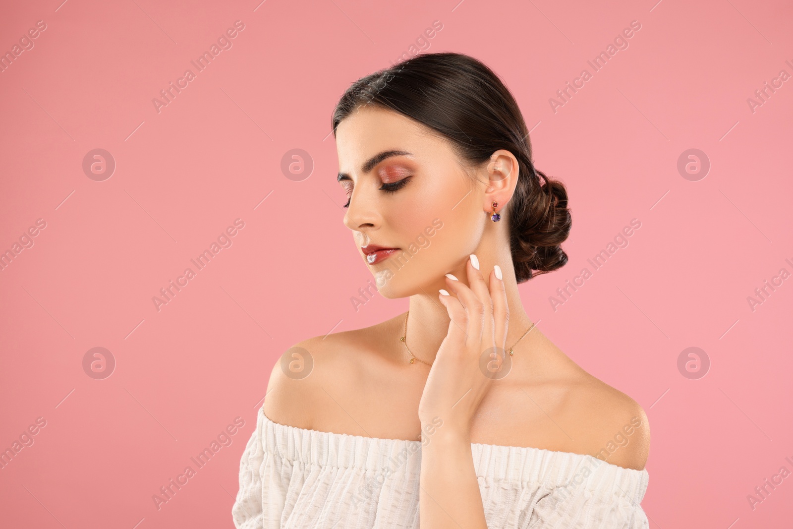 Photo of Beautiful woman with elegant jewelry on pink background, space for text