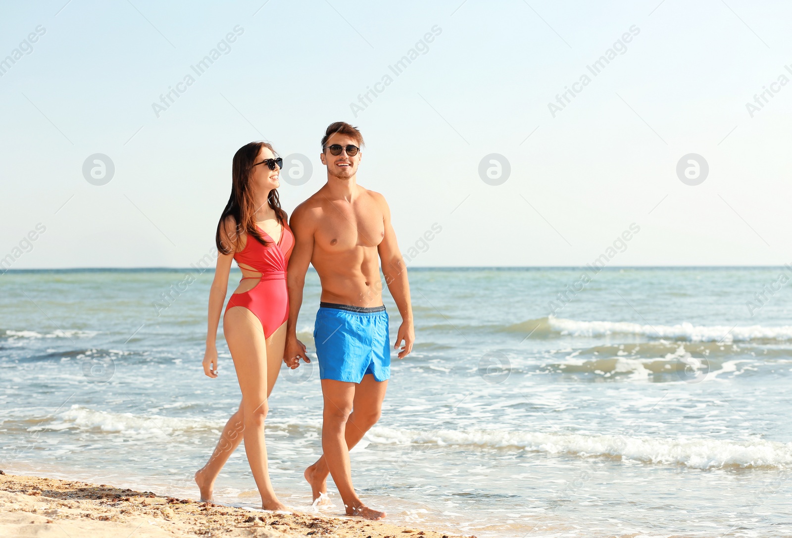 Photo of Happy young couple walking together on beach