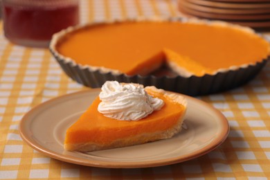 Photo of Piece of fresh homemade pumpkin pie with whipped cream on table