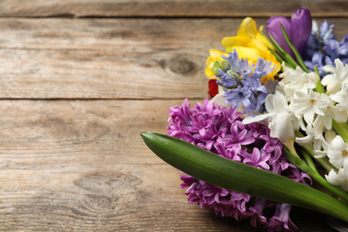 Photo of Bouquet of beautiful spring flowers on wooden table, closeup. Space for text