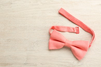 Photo of Stylish pink bow tie on wooden background, top view. Space for text