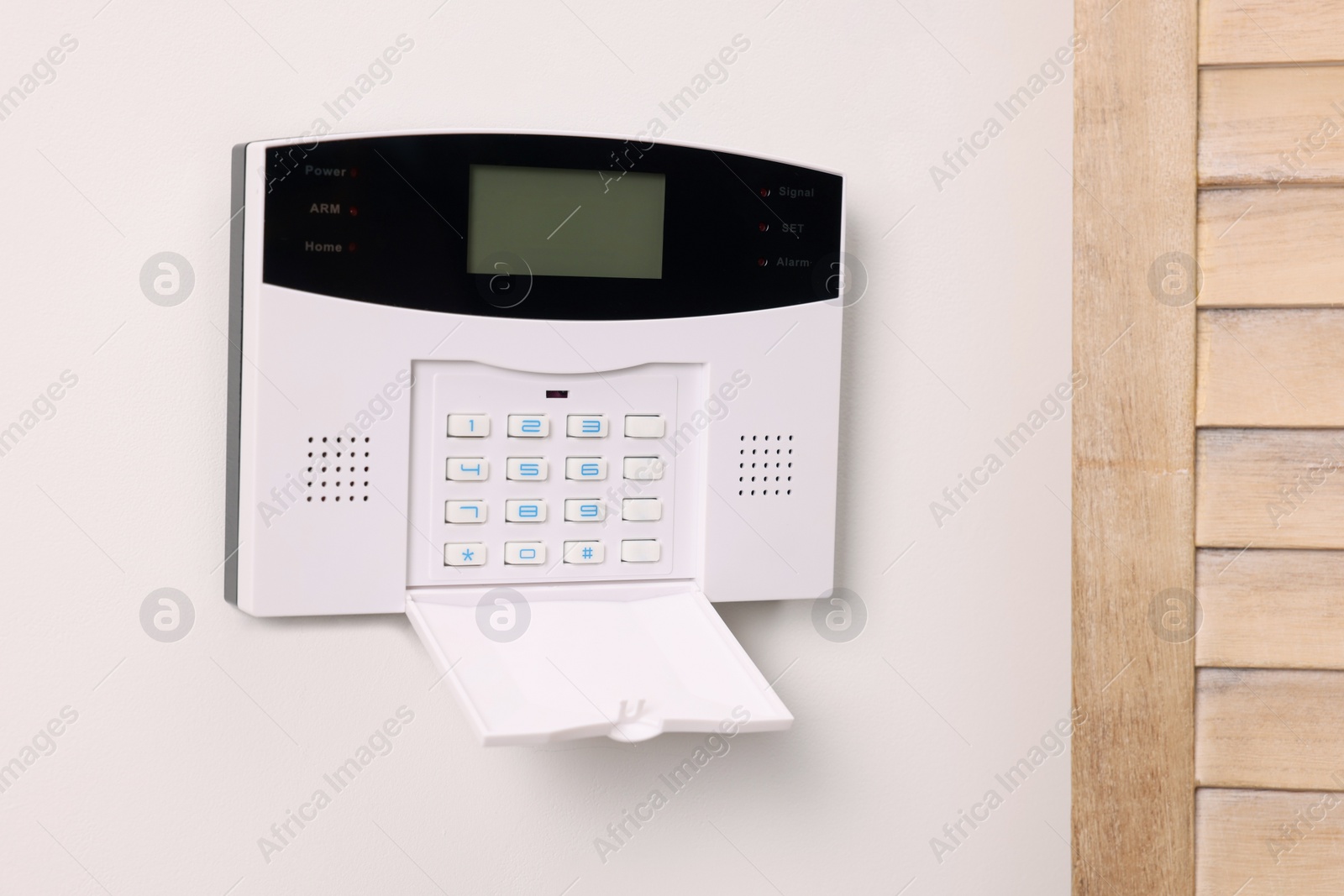 Photo of Home security alarm system on white wall indoors