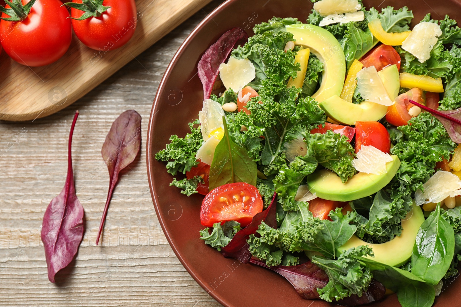 Photo of Tasty fresh kale salad on wooden table, flat lay