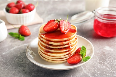 Photo of Plate with pancakes and berries on table