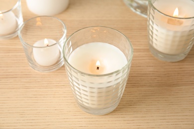 Burning aromatic candles on wooden table. Interior decor