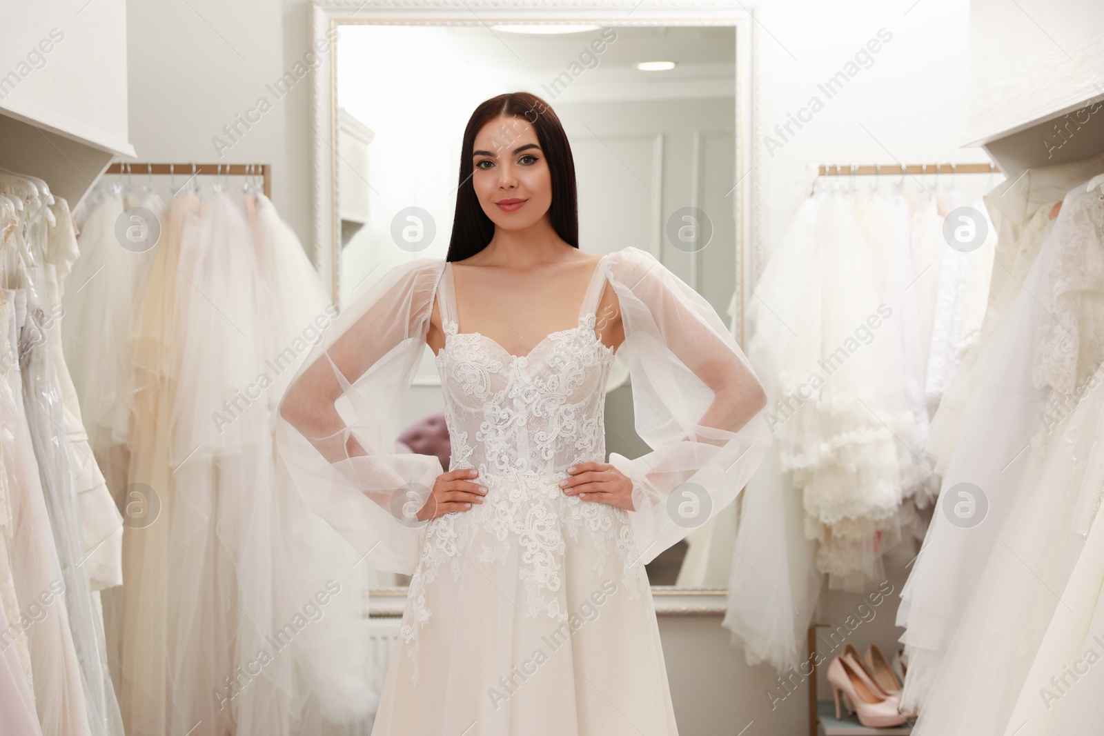 Photo of Woman trying on beautiful wedding dress in boutique