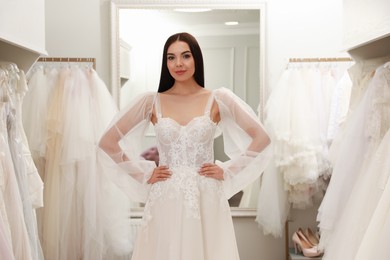 Woman trying on beautiful wedding dress in boutique