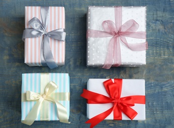 Photo of Beautifully decorated gift boxes on wooden background, top view