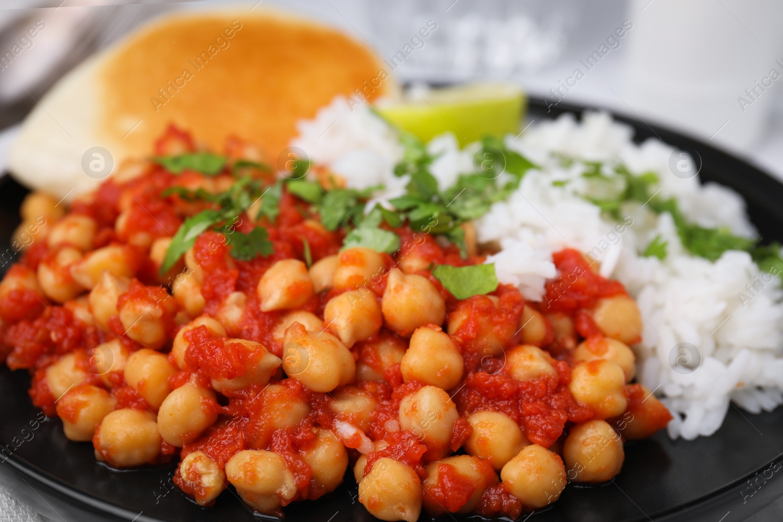 Photo of Delicious chickpea curry with rice on table, closeup