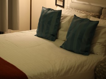 Comfortable bed with soft pillows in room