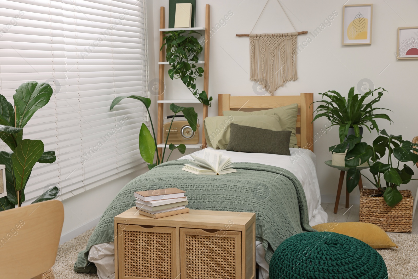 Photo of Large comfortable bed and potted houseplants in stylish bedroom. Interior design