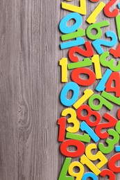 Colorful numbers on wooden school desk, flat lay. Space for text