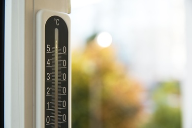 Photo of Weather thermometer on window frame indoors, closeup. Space for text