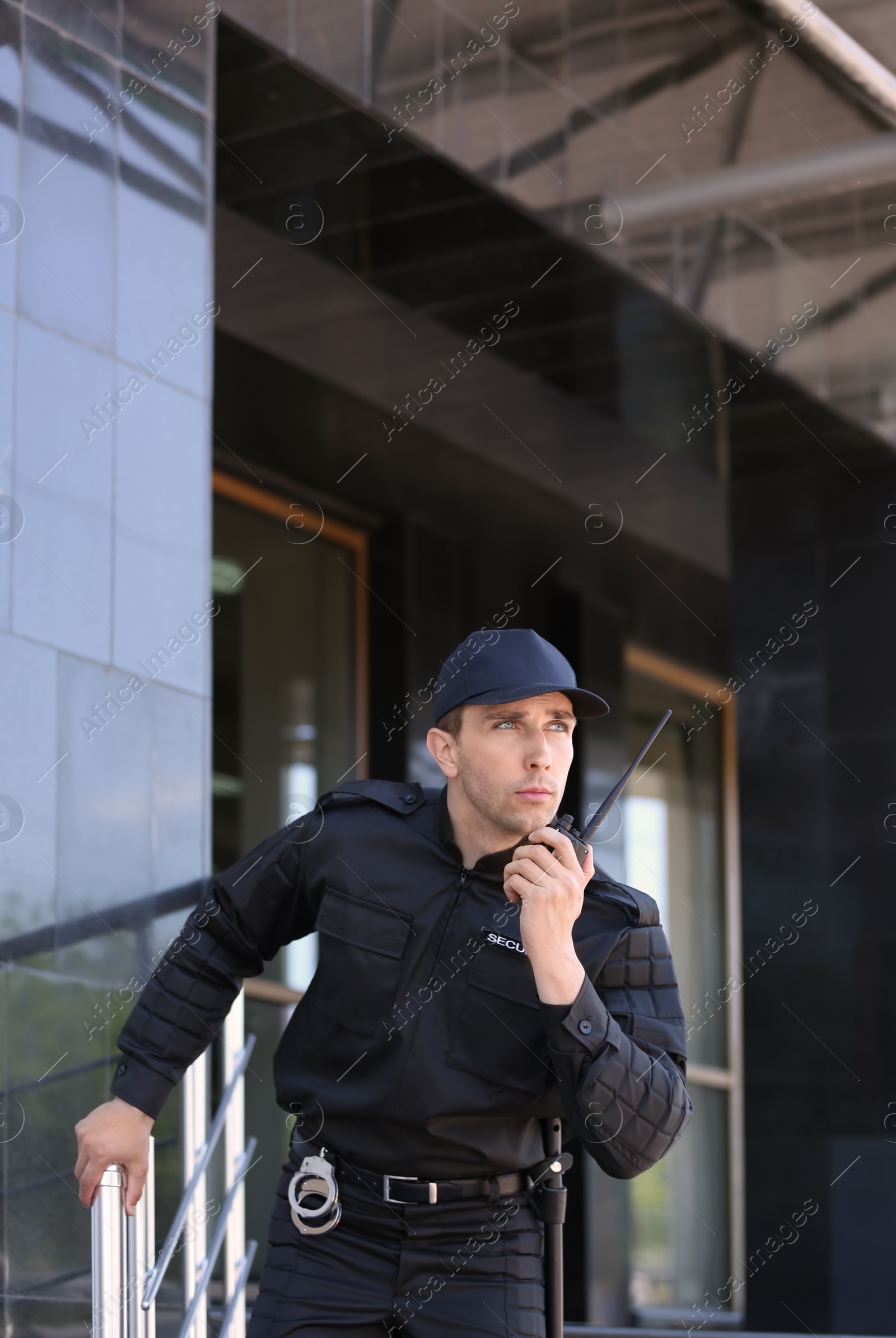 Photo of Male security guard using portable radio transmitter outdoors