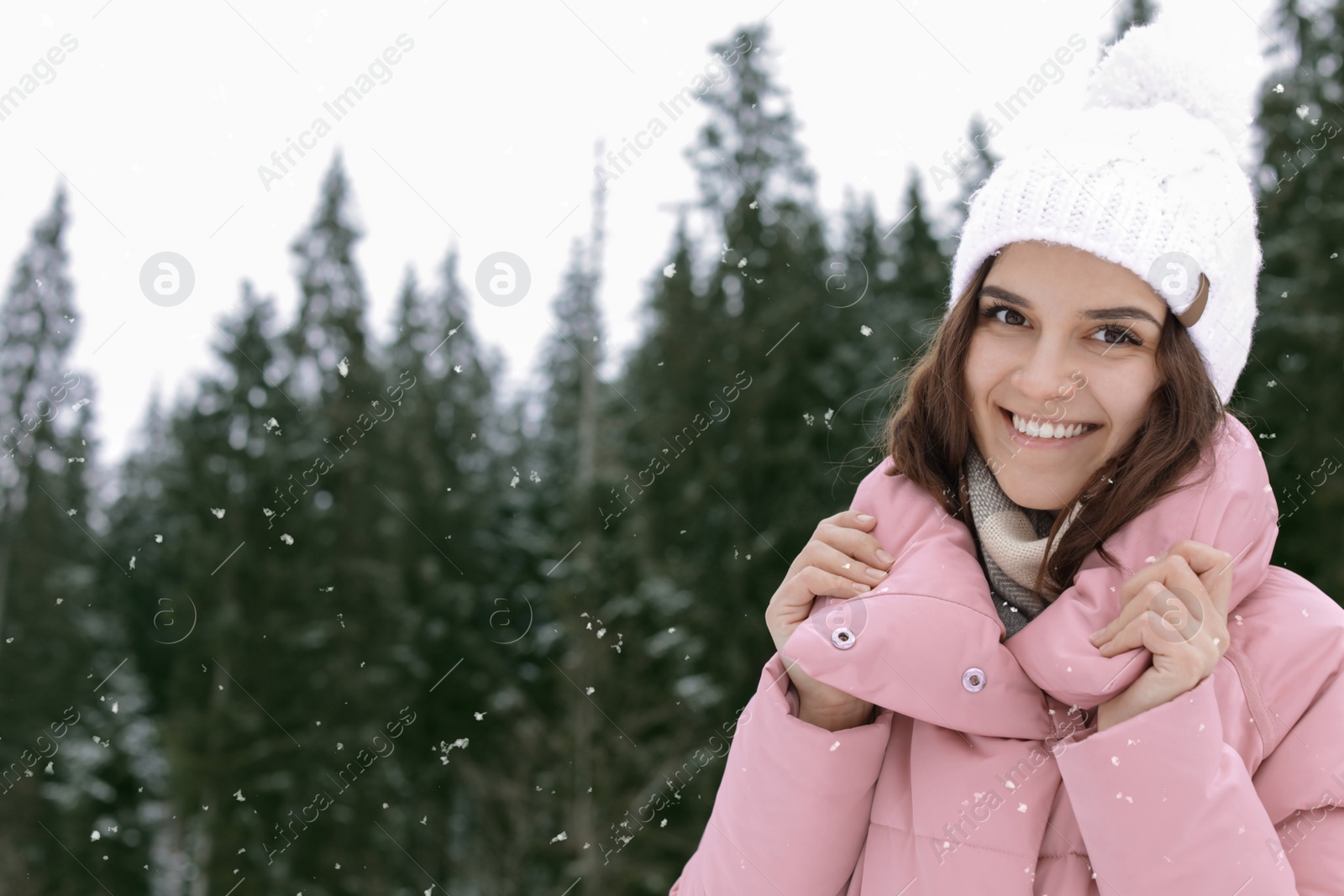 Photo of Happy young woman in warm clothes outdoors, space for text. Winter vacation