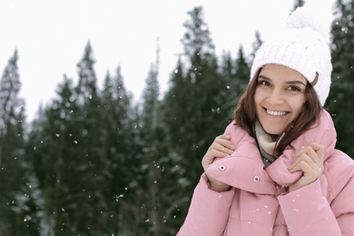 Photo of Happy young woman in warm clothes outdoors, space for text. Winter vacation