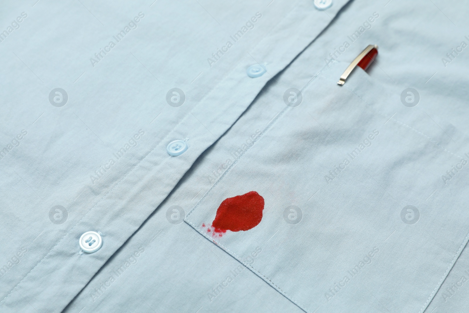 Photo of Shirt with stain of red ink and pen in pocket, closeup