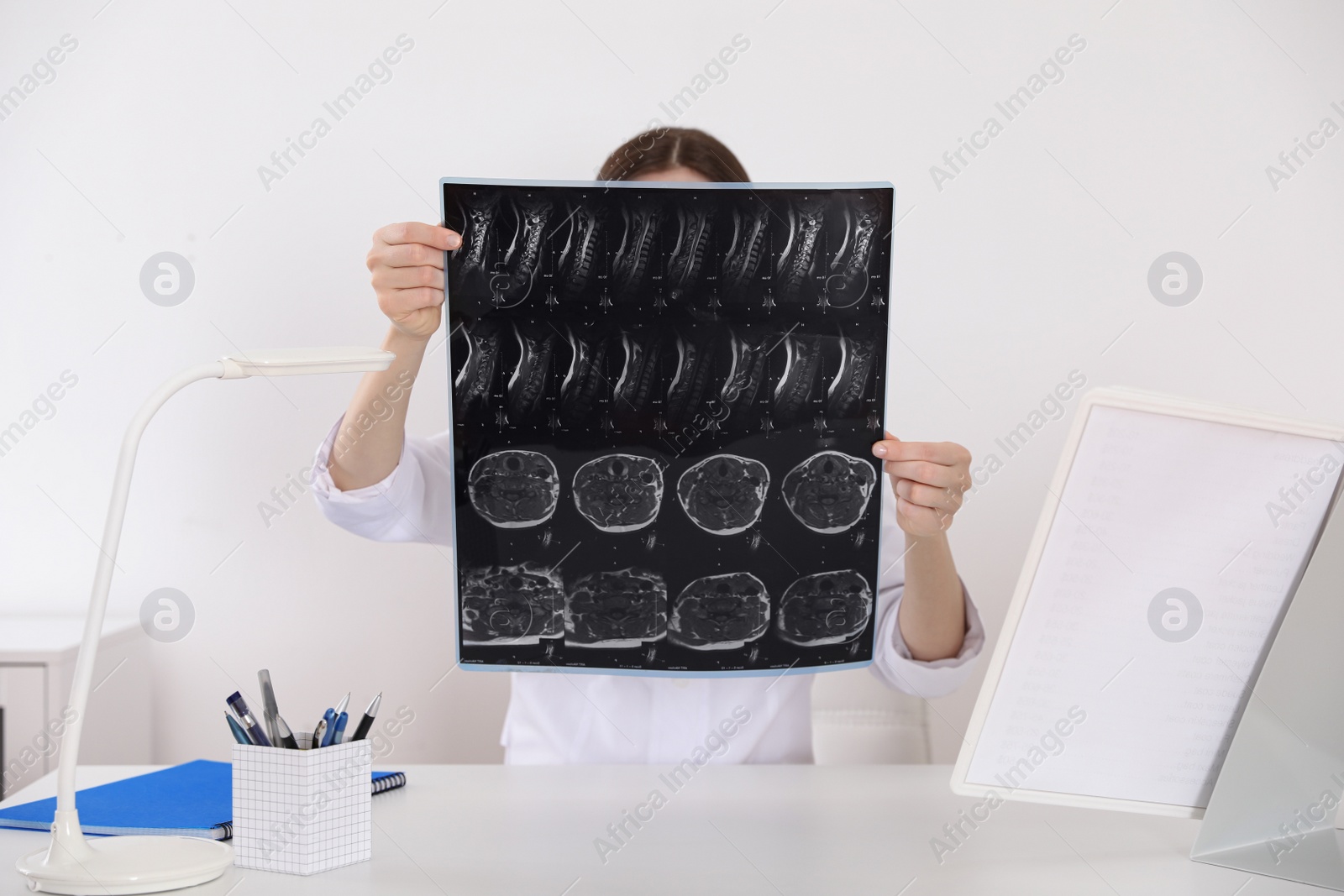 Photo of Orthopedist examining X-ray picture at desk in clinic