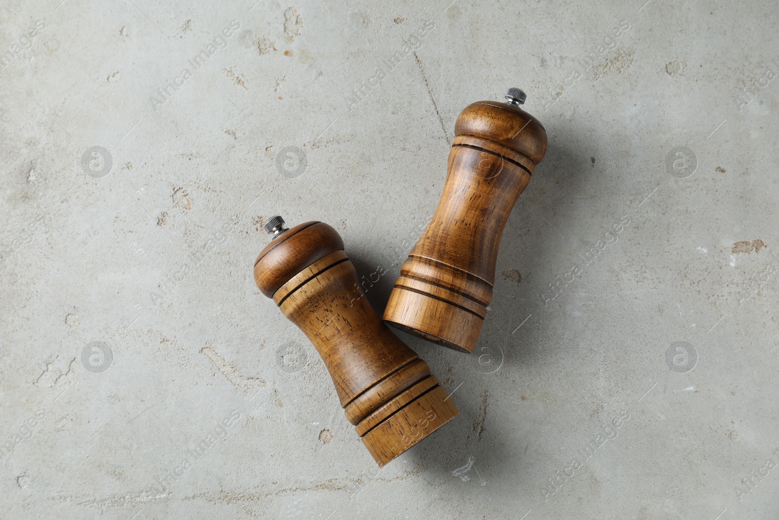 Photo of Wooden salt and pepper shakers on light textured table, top view