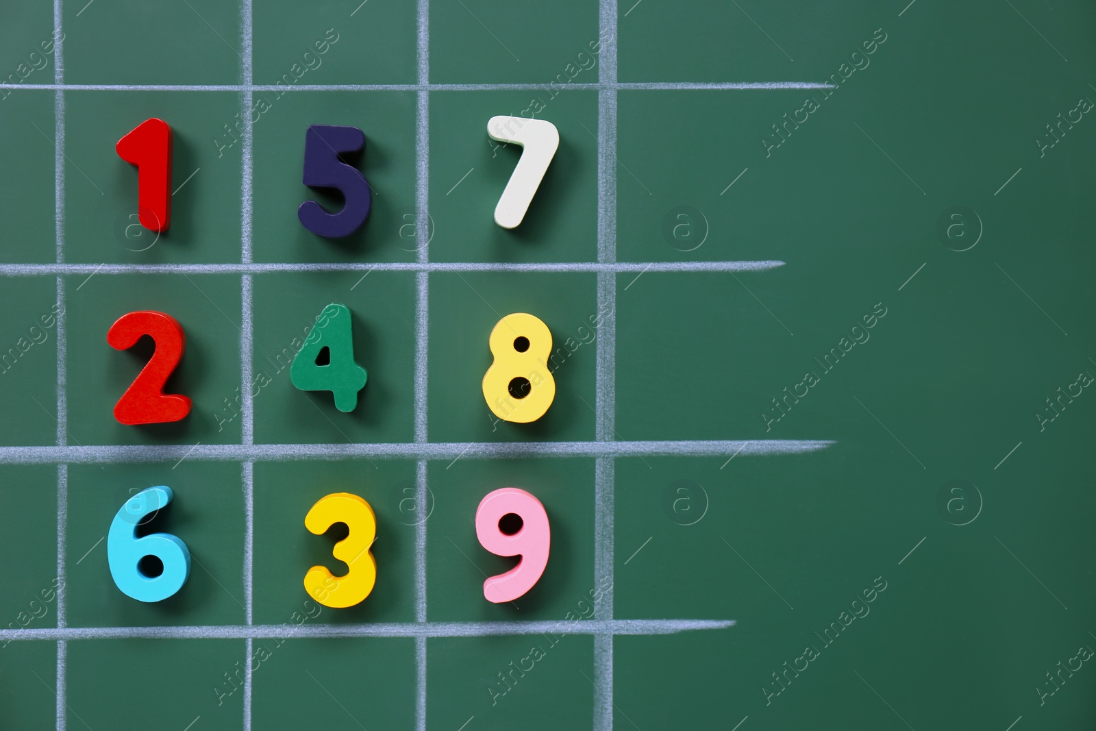 Photo of Many colorful numbers on green chalkboard, flat lay