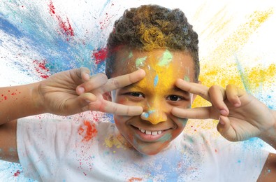Holi festival celebration. Happy boy covered with colorful powder dyes on white background