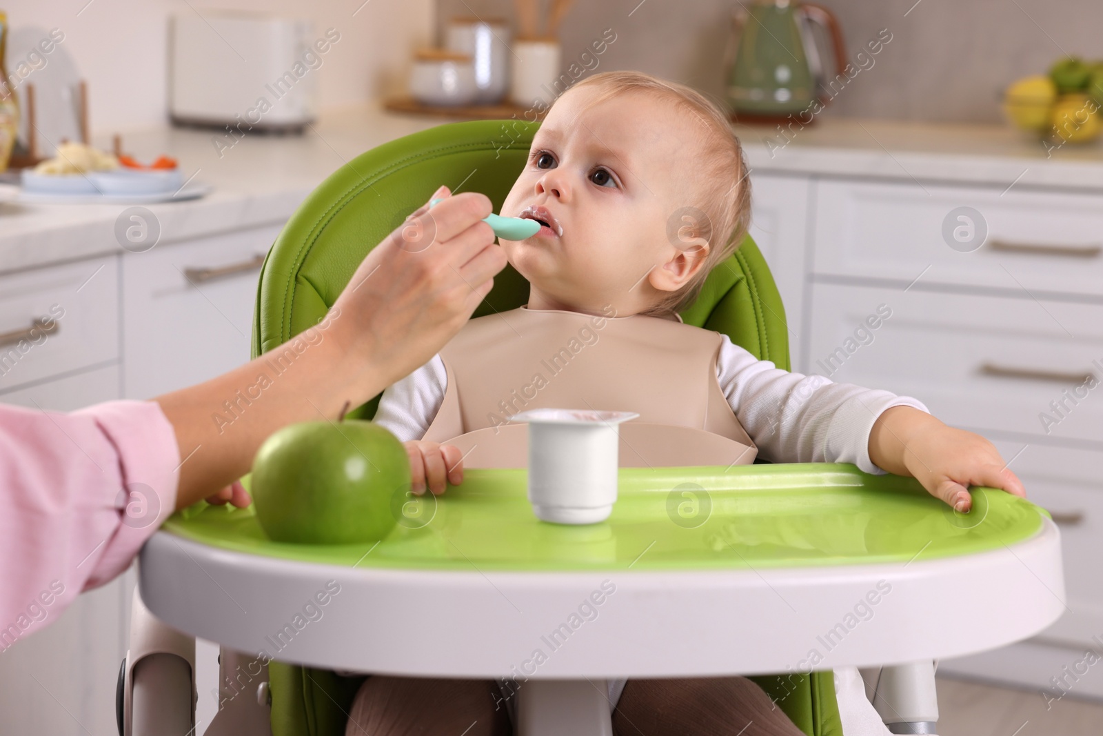 Photo of Mother feeding her cute little baby with healthy food at home