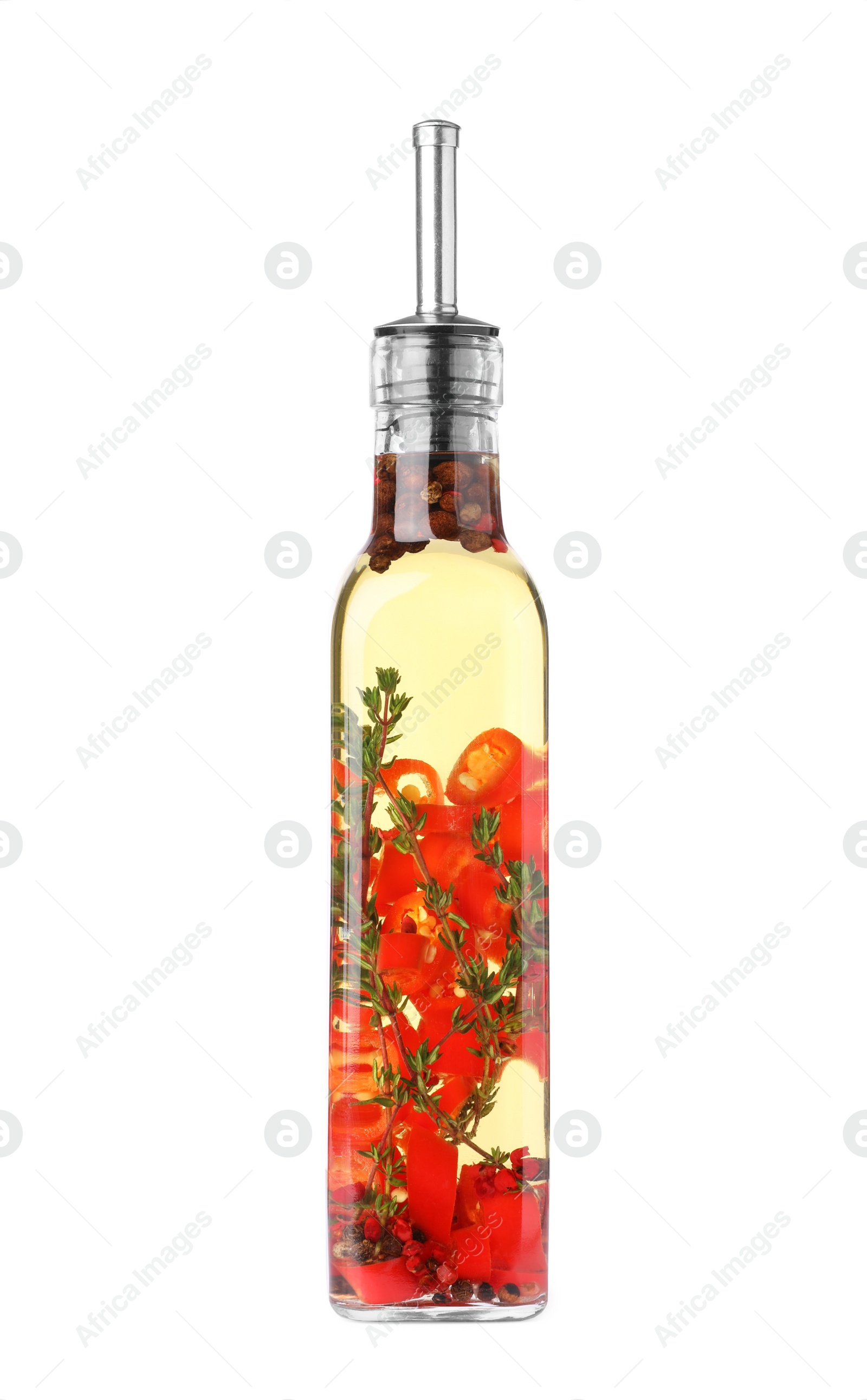 Photo of Glass bottle of cooking oil with spices and herbs isolated on white